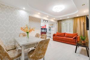 ein Wohnzimmer mit Tisch und Couch in der Unterkunft Трехкомнатная квартира рядом с ЖД вокзалом in Pawlodar