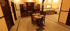 a dining room with a table and chairs in a living room at Golden Horizon Suite in Lahore
