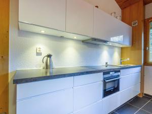 una cucina con mobili bianchi e un lavandino di Appartement Rénové 3 Pièces Mezzanine à 50m des Pistes, Balcon, Lave-Linge et Casier à Skis - FR-1-356-206 a Valmorel