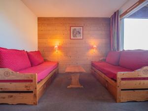 une chambre avec deux lits et une table dans l'établissement Studio skis aux pieds à Valmorel, proche ESF et commerces, animaux acceptés - FR-1-356-180, à Valmorel