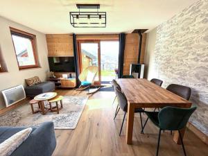 a living room with a wooden table and chairs at Chalet 3* Valmorel, skis aux pieds, 3 chambres, parking, WIFI - FR-1-356-401 in Valmorel