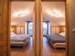 two beds in a room with two windows at Chalet 3* Valmorel, skis aux pieds, 3 chambres, parking, WIFI - FR-1-356-401 in Valmorel