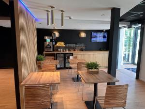 a restaurant with wooden tables and chairs at Hôtel Akena Pierrelaye in Pierrelaye