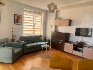 a living room with a couch and a tv at Asinela Home с гараж in Burgas City +26 photos
