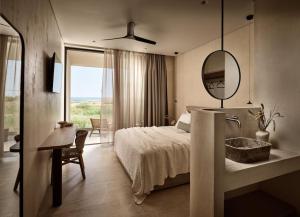a bedroom with a bed and a mirror and a sink at Mayamor Villas, sea view to Tsilivi beach in Tsilivi