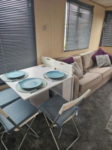 a living room with a table and chairs and a couch at 64 Whitehouse in Abergele