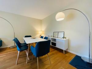een eetkamer met een tafel en blauwe stoelen bij Casa du Haras in Angers