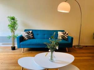 een woonkamer met een blauwe bank en een tafel bij Casa du Haras in Angers