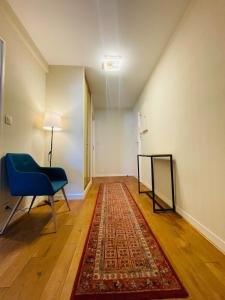 een lege kamer met een blauwe stoel en een kleed bij Casa du Haras in Angers +14 foto's