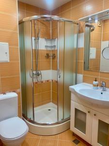 a bathroom with a shower and a toilet and a sink at Asinela Home с гараж in Burgas City