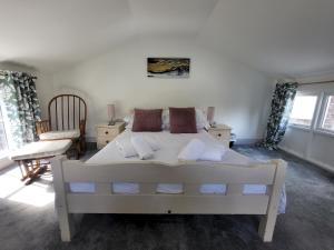 a bedroom with a large white bed and a chair at Juniper HAYLOFT Grasmere in Ambleside +12 photos