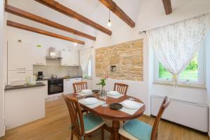a kitchen and dining room with a wooden table and chairs at Villa Dobrila by IstriaLux in Stari Pazin