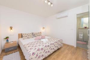 a white bedroom with a bed and a wooden floor at Villa Dobrila by IstriaLux in Stari Pazin +32 photos