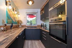 a kitchen with black cabinets and a wooden counter top at Upton 2 - Arradon Golfe du Morbihan in Arradon +14 photos