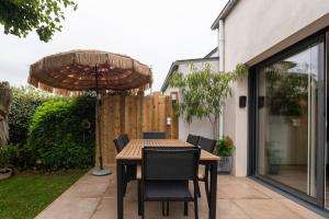 a table with chairs and an umbrella on a patio at Upton 2 - Arradon Golfe du Morbihan in Arradon