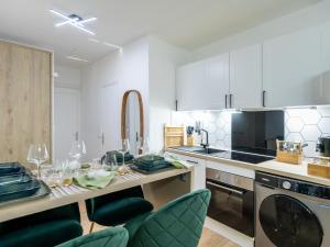 una cucina con armadi bianchi e un tavolo con bicchieri da vino di La petite Rosée - Vienna authentica a Vienne Altre 7 foto