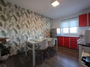 een keuken met een tafel en stoelen en rode kasten bij Apartment in Banjole - Istrien 11157 in Banjole