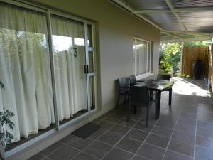 a porch with a table and chairs and windows at Brand Guesthouse in Colesberg