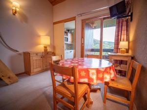 une salle à manger avec une table et des chaises et une fenêtre dans l'établissement Valmorel : Duplex cosy au pied des pistes, balcon, animaux admis ! - FR-1-356-299, à Valmorel