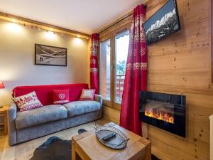 a living room with a couch and a fireplace at Appartement rénové à Méribel, proche pistes, balcon, 4 couchages - FR-1-355-108 in Méribel
