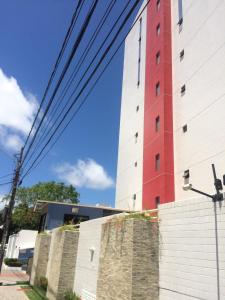 un edificio rojo y blanco junto a una pared en Apartamento Praia De Manaíra, en João Pessoa