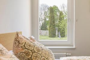 a window in a bedroom with a pillow on a bed at Apartment Premium im Gustav Seitz Gästehaus in Trebnitz