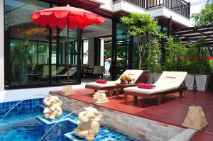 a house with a pool with teddy bears sitting on a patio at Royal Thai Pavilion Jomtien Hotel in Jomtien Beach