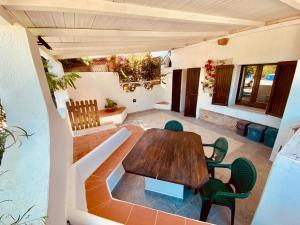 Un patio al aire libre con una mesa y sillas de madera. en A.I.R. Villa Marinedda, en Isola Rossa