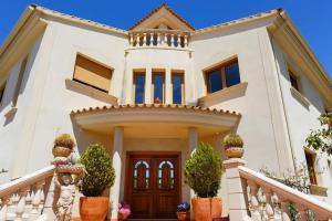 a white house with potted plants in front of it at BEACH VILLA with PRIVATE POOL in Palma de Mallorca