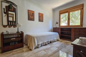 a bedroom with a bed and a dresser and a window at BEACH VILLA with PRIVATE POOL in Palma de Mallorca