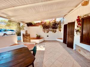 Un patio al aire libre con mesa y sillas. en A.I.R. Villa Marinedda, en Isola Rossa