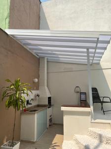 a roof over a kitchen with a table and a chair at Casa com piscina, churrasqueira e terraço com vista pro mar! in Mangaratiba