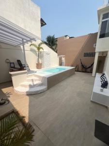 a patio with a swimming pool and a house at Casa com piscina, churrasqueira e terraço com vista pro mar! in Mangaratiba
