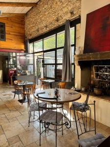a dining room with tables and chairs and a fireplace at La fontaine de rocoule in Rochefort-en-Valdaine