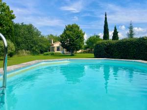 a blue swimming pool in front of a house at 349 Les Maridats in Bédoin +11 photos