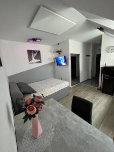 a living room with a table and a bed at ApartmaSLB in Slovenska Bistrica