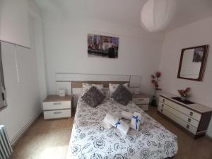 sypialnia z łóżkiem z 2 stolikami nocnymi i 2 stołami w obiekcie Piso turístico en el centro de Benavente w mieście Benavente