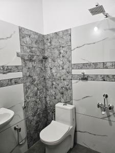 a bathroom with a toilet and a sink at MetroNova Homes - Furnished stay in Ambalappuzha in Alleppey +5 photos