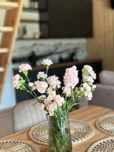 a vase of pink flowers sitting on a table at Domki Trzy Szczyty in Daleszyce +63 photos