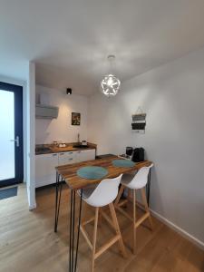 a kitchen and dining room with a wooden table and chairs at Casa en Sol - 5 min walk to Therme Balotesti in Baloteşti