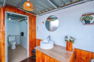 a bathroom with a sink and a toilet and a mirror at ชิวชิวแคมป์ ภูชี้ฟ้า in Ban Huai Han