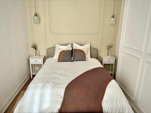 een slaapkamer met een bed met 2 nachtkastjes bij Eleven Arene BY PRIMO C0NCIERGERIE in Bourges