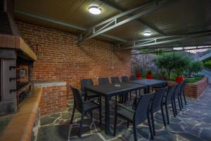a patio with a table and chairs and a brick wall at Xhuli Guesthouse in Shirokë
