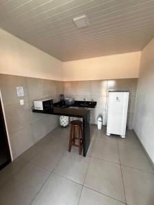 a small kitchen with a counter and a refrigerator at Vento Leste Suites in Flecheiras