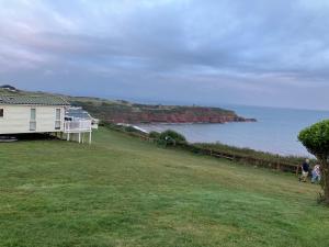 a house on a hill next to the ocean at Devon Cliffs Exmouth Sandy Bay 3 bedrooms in Exmouth +8 photos