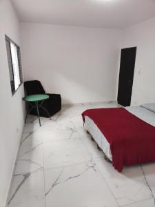 a white room with a bed and a green table at 11Suites casa Suite #8 in Caraguatatuba +8 photos