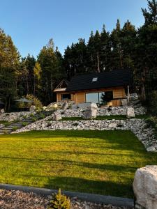 una casa con un muro di pietra e una casa di Domki Trzy Szczyty a Daleszyce