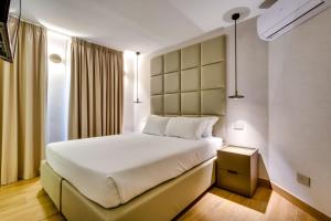 a bedroom with a large white bed in a room at Relais Badoer in Rome