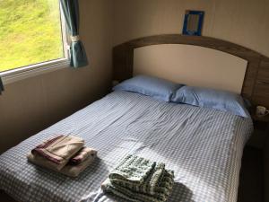 a bed with two bags on it in a bedroom at Devon Cliffs Exmouth Sandy Bay 3 bedrooms in Exmouth
