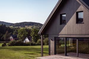 a house with large windows and a view of a yard at Chalupa U Krtka in Bělá pod Pradědem +37 photos
